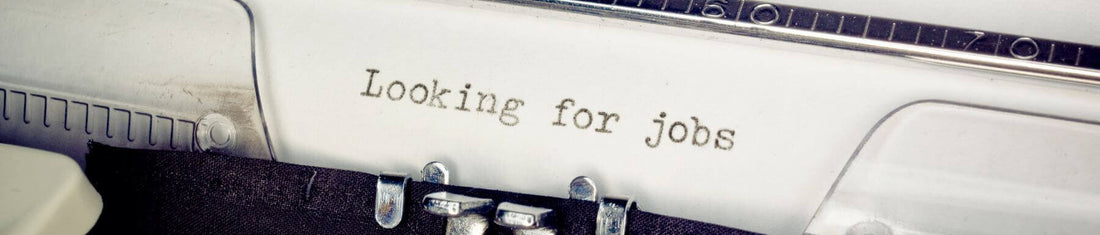 Header image for blog about job hunting, featuring a laptop with a resume on the screen, a briefcase, and a job interview outfit.