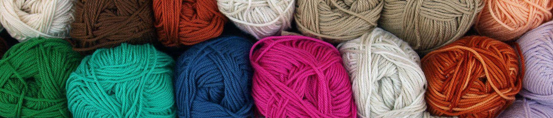 Header image for blog about crocheting, featuring colorful yarn skeins, crochet hooks, and handmade crochet projects.