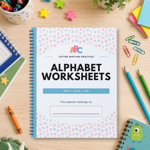 A spiral-bound workbook titled 'Alphabet Worksheets' lies on a light wood desk surrounded by school supplies, including colored pencils, paper clips, crayons, sticky notes, and other notebooks.