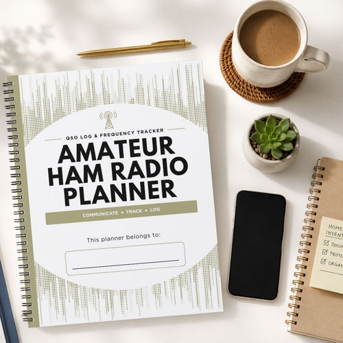 A spiral-bound Amateur Ham Radio Planner notebook is shown in a styled flat-lay arrangement on a white surface, surrounded by a coffee cup, a pen, a small succulent, a smartphone, and another notebook.