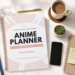 A spiral-bound 'Anime Planner' notebook is displayed in a styled flat-lay arrangement on a white surface, surrounded by a cup of coffee, a smartphone, a small succulent, and another notebook.