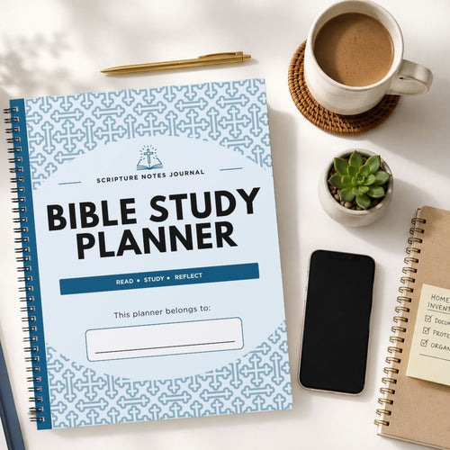 A Bible Study Planner journal with a light blue and white geometric pattern cover, styled in a flat-lay arrangement on a white desk alongside a cup of coffee, a pen, a small succulent, a smartphone, and another notebook.