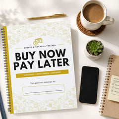 A spiral-bound budget and financial tracker planner titled 'BUY NOW PAY LATER' is shown in a styled flat-lay arrangement on a white surface, alongside a coffee cup, pen, phone, small succulent, and another notebook.