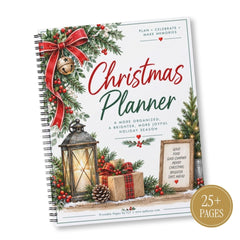 A spiral-bound Christmas planner shown at an angle on a white background. The cover features festive holiday illustrations including a red bow, green pine garlands, red berries, wrapped gifts, a lantern, and a small framed sign with holiday phrases.
