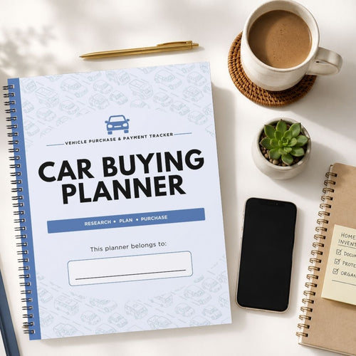 A spiral-bound 'Car Buying Planner' notebook is displayed in a styled flat-lay arrangement on a white desk, surrounded by a cup of coffee, a smartphone, a small succulent, and other notebooks.