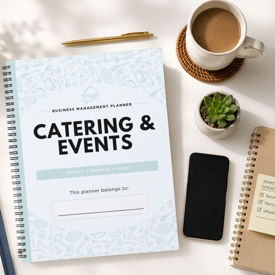 A spiral-bound business management planner titled 'Catering & Events' is shown in a styled flat-lay arrangement on a white surface, alongside a cup of coffee, a pen, a small succulent, a smartphone, and another notebook.