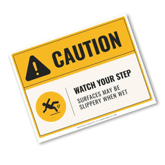 A caution slip-and-fall warning sign with a yellow and white background, black text reading 'CAUTION' and 'WATCH YOUR STEP SURFACES MAY BE SLIPPERY WHEN WET', plus a slipping figure icon. The sign is shown at an angle on a plain white background.