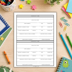 A printed emergency card template sheet displayed on a light wood desk surrounded by school and office props including notebooks, pencils, paper clips, and a crayon.