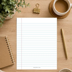 A white lined notepad sheet centered on a light wood desk, surrounded by a brown notebook, gold binder clip, white coffee cup, pen, and small plant.