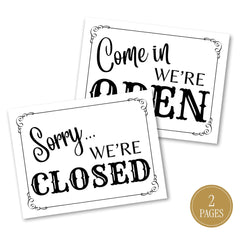 Two white printed signs with black decorative text reading 'Sorry we're closed and come in we're open.