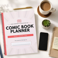 A spiral-bound comic book planner with a white cover and coral-red accents is shown in a styled flat-lay on a light surface, alongside a coffee cup, pen, small plant, smartphone, and another notebook.