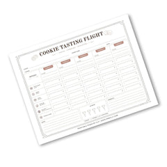 A printable 'Cookie Tasting Flight' chart template shown on a clean white background. The sheet features a grid with columns for days of the week and rows for taste, texture, and appearance, with a decorative border.