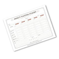 A printable donut tasting flight chart template shown at an angle on a white background. The form features columns for date, time, temperature, and scores across categories like flavor, texture, and packaging.