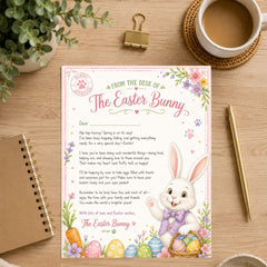 A printed Easter bunny letter card with floral illustrations and a cartoon bunny, styled on a wooden desk with a coffee cup, plant, binder clip, notebook, and gold pen.