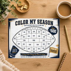 A football-themed 'Color My Season' fundraising game board displayed on a wooden desk with coffee, a plant, and stationery around it.