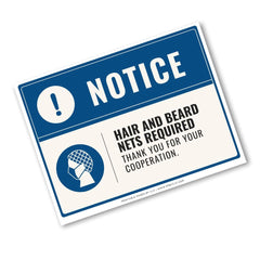 A rectangular blue and white notice sign with bold text reading 'NOTICE' and 'HAIR AND BEARD NETS REQUIRED THANK YOU FOR YOUR COOPERATION.' A small icon of a face with a beard net is shown on the sign, photographed on a light gray background.