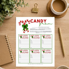 A printable holiday game sheet titled 'CANDY gram' with six 'Happy Holidays' cards, styled on a wooden desk with a coffee cup, plant, notebook, and gold pen.