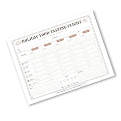 A printable holiday food tasting flight chart template shown at an angle on a white background. The sheet features columns for days of the week, food categories, ratings, and notes, with a clean minimalist design in black and muted brown tones.