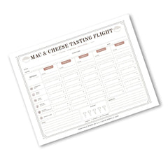A printed 'Mac & Cheese Tasting Flight' log sheet with columns for date, temperature, and cheese ratings, shown at an angle on a white background.