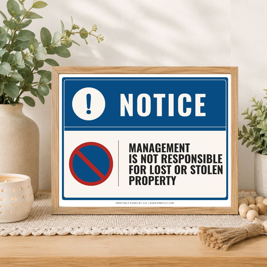 A framed warning sign with a blue and white background, featuring the word 'NOTICE' and a red-and-blue no symbol with the text 'Management is not responsible for lost or stolen property.' The sign is displayed on a tabletop in a styled interior setting with plants, a candle, and decorative beads.