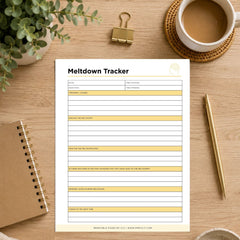 A printable 'Meltdown Tracker' sheet displayed on a wooden desk flat-lay. The tracker features clean black text, white background, and light yellow highlight bars for writing.