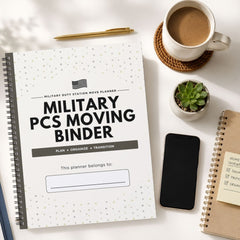 A spiral-bound planner titled 'Military PCS Moving Binder' shown in a styled flat-lay on a white surface, surrounded by a cup of coffee, a pen, a small succulent, a smartphone, and another notebook.