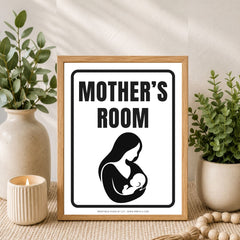 A framed print with the words “MOTHER’S ROOM” and a black silhouette of a mother holding a baby, styled on a tabletop with plants, a candle, and a wooden bead runner.