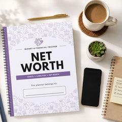 A spiral-bound Net Worth Budget & Financial Tracker planner is shown in a styled flat-lay arrangement on a white surface, surrounded by a cup of coffee, a pen, a small succulent, a smartphone, and another notebook.