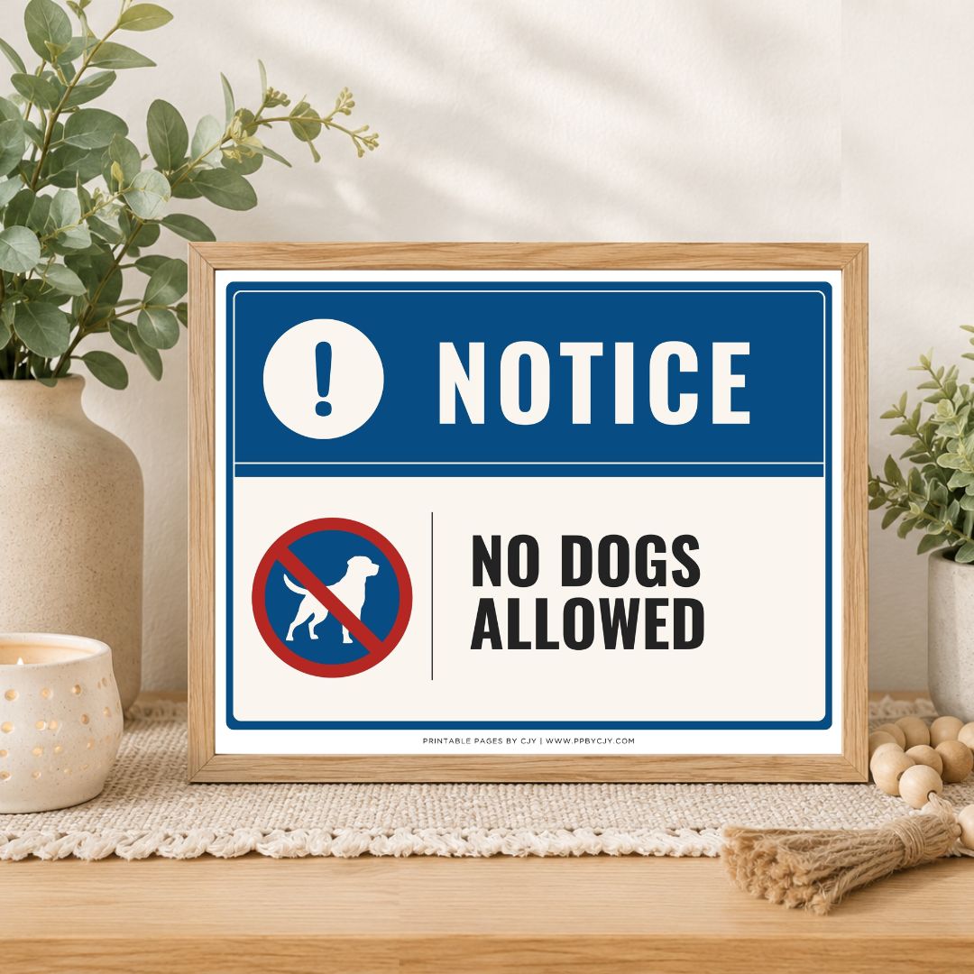 A framed 'No Dogs Allowed' sign displayed on a wooden table in a styled home setting with plants and decorative items.