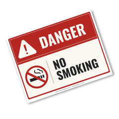 A rectangular warning sign with a red header reading DANGER and a white lower section that says NO SMOKING, with a no-smoking symbol and a white border, shown on a light gray background.