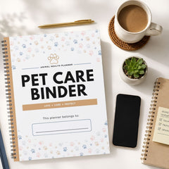 A spiral-bound Pet Care Planner notebook is shown in a styled flat-lay arrangement on a white surface, surrounded by a coffee cup, a pen, a small succulent, a smartphone, and another notebook.