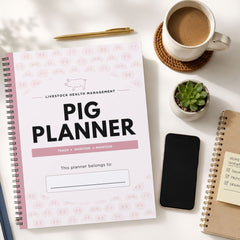 A spiral-bound pig planner titled 'Livestock Health Management Pig Planner' is shown in a styled flat-lay on a white surface, surrounded by a coffee cup, pen, phone, notebook, and small succulent.