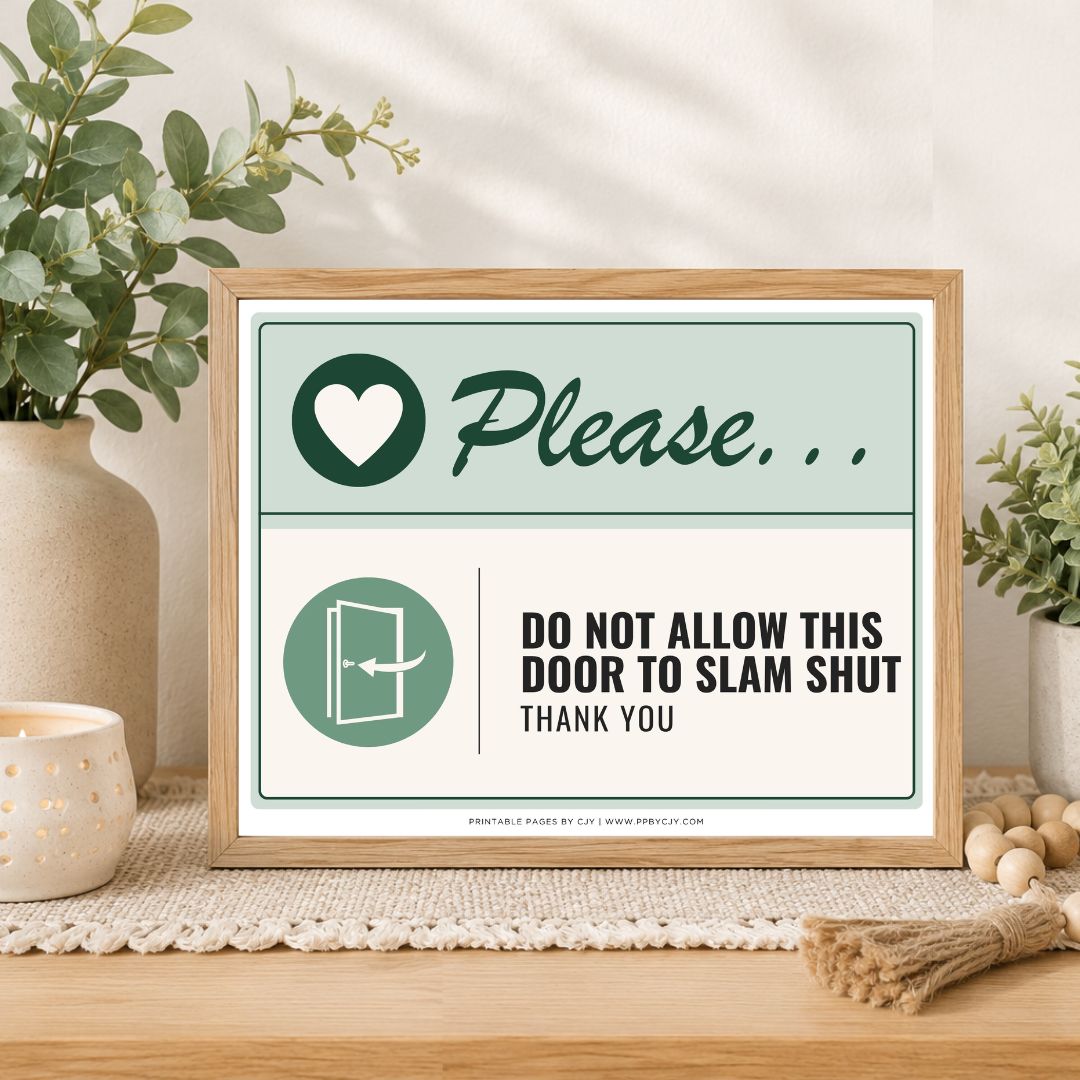 A framed decorative sign on a wooden table in a styled interior setting. The sign has a light wood frame and reads 'Please.