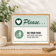 A framed printed sign on a wooden surface in a styled interior setting. The sign reads 'Please.