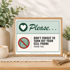 A framed printed sign on a tabletop in a styled interior setting. The sign reads 'Please.