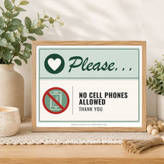 A framed printed sign on a tabletop in a styled interior setting. The sign reads 'Please.