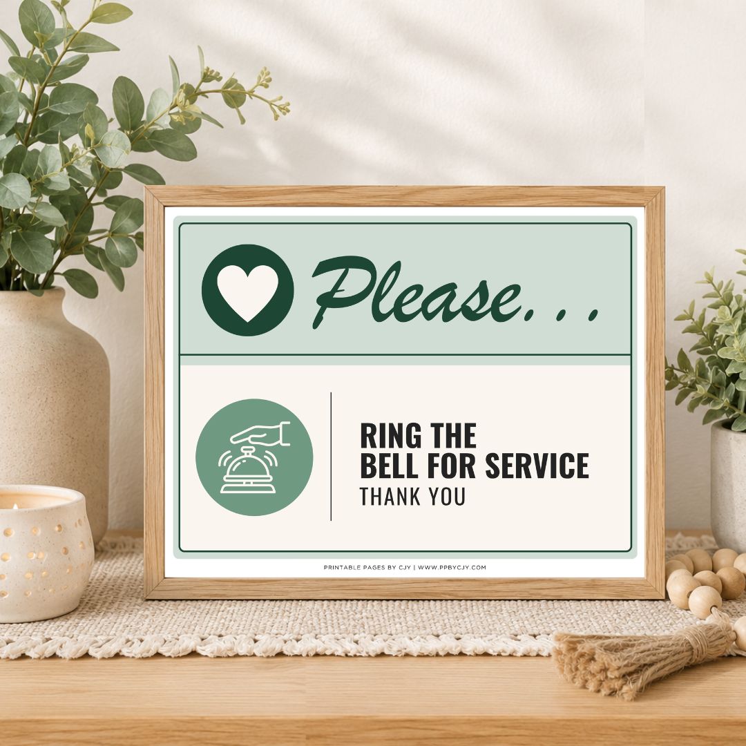 A framed printed sign on a tabletop in a styled interior setting. The sign has a light wood frame and reads 'Please.