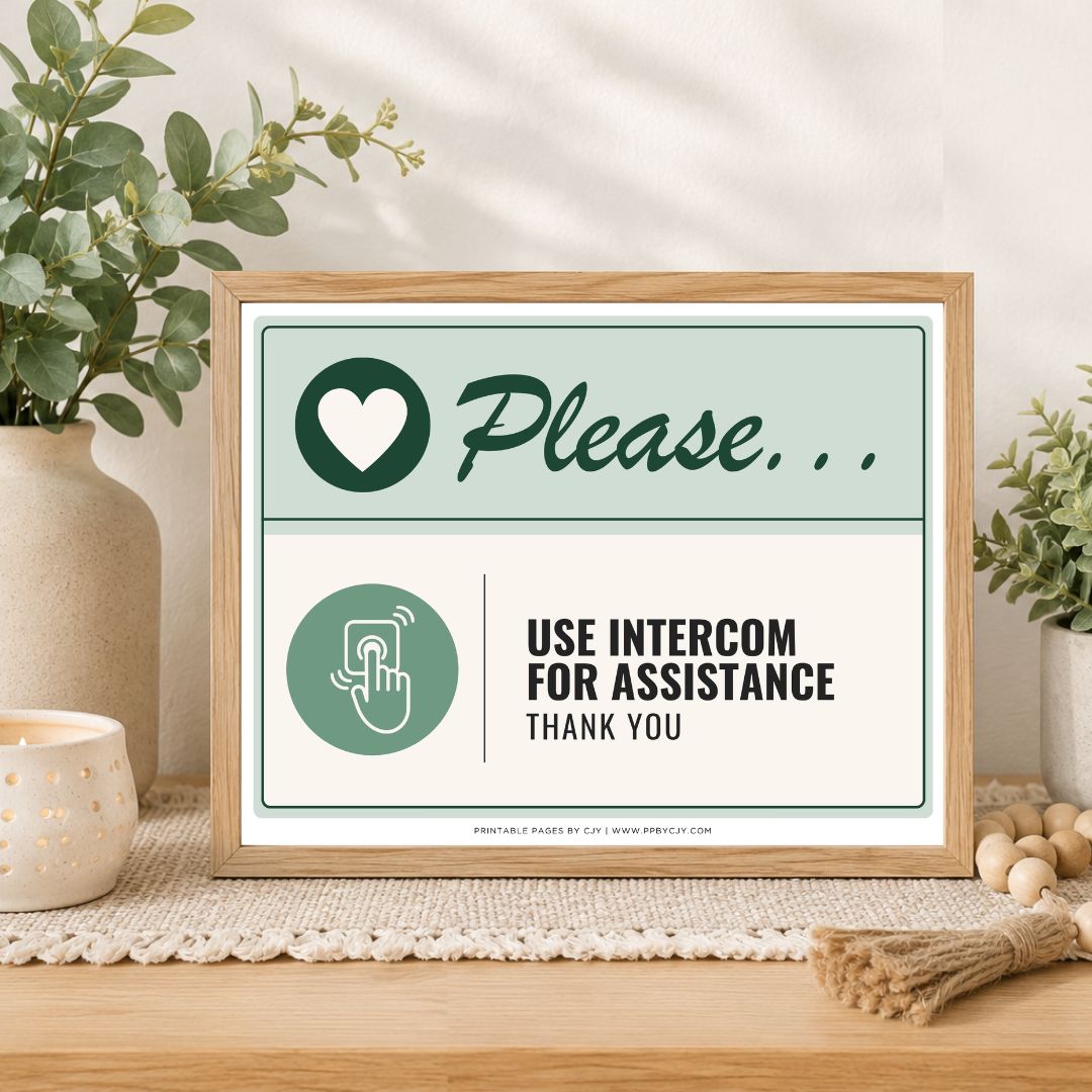 A framed printed sign on a wooden table in a styled interior setting. The sign reads 'Please.