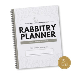 A spiral-bound 'Rabbitry Planner' with a white cover decorated with light gray bunny sketches. The cover features bold black text reading 'RABBITRY PLANNER' and a gray bar that says 'TRACK | MONITOR | MAINTAIN'.
