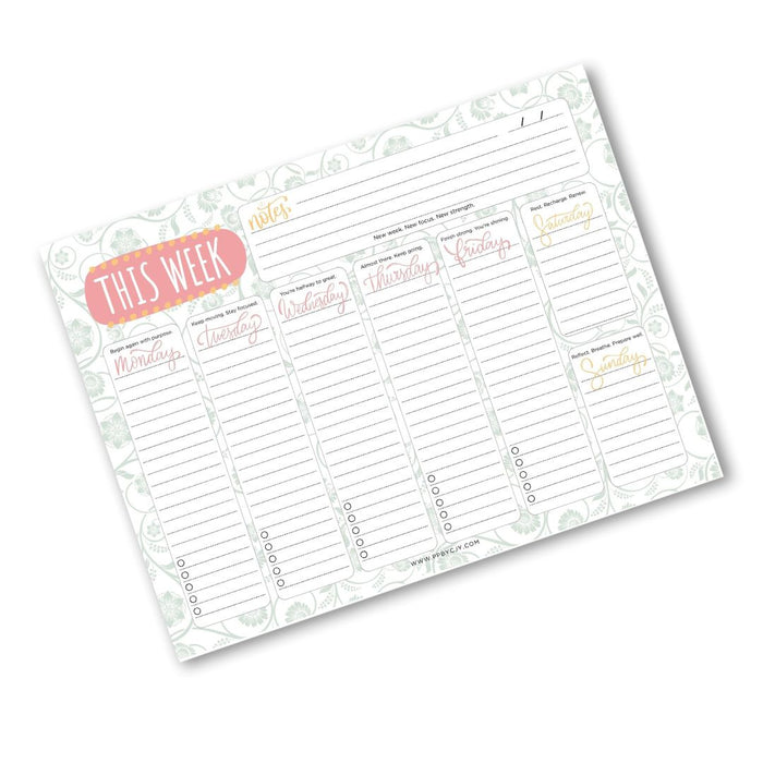 A weekly planner notepad with a white background, light green floral border, a coral pink 'THIS WEEK' header, and sections for Monday through Sunday with lined writing areas and a note box.