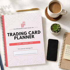 A spiral-bound Trading Card Planner notebook is shown in a styled flat-lay arrangement on a white surface, alongside a cup of coffee, a small succulent, a smartphone, and another notebook.