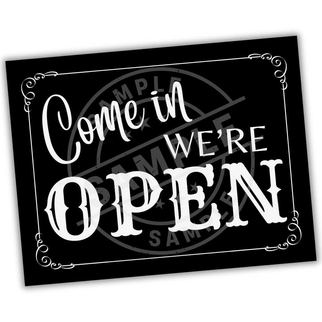 Black sign with white text 'Come in WE'RE OPEN' on a white background