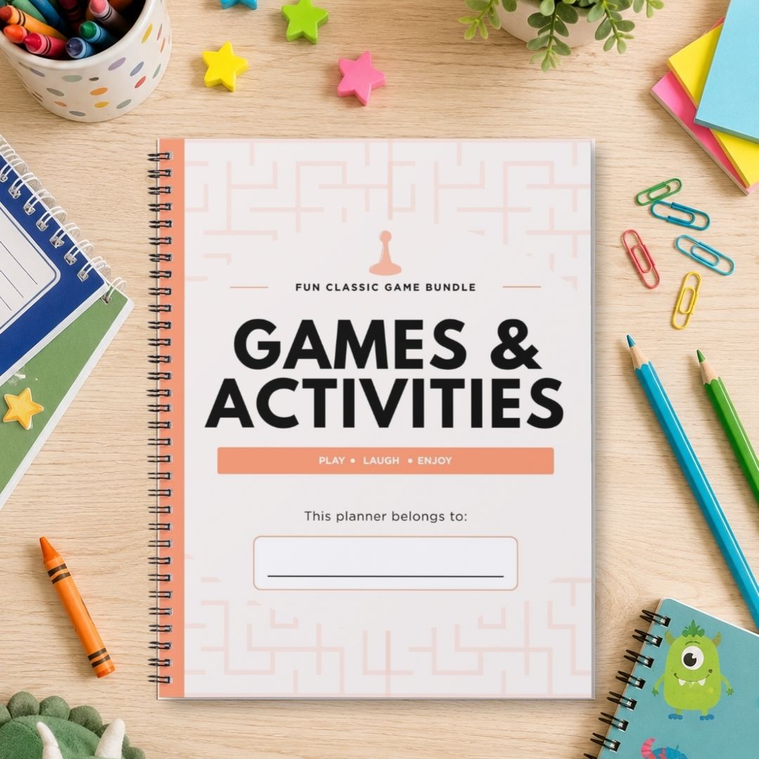 A spiral-bound planner or notebook titled "Games & Activities" lies on a light wood desk surrounded by school and play props, including colored pencils, paper clips, star stickers, a plant, and other notebooks.