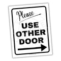 Sign with text 'Please Use Other Door' and an arrow on a white background