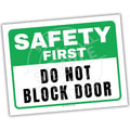 Safety sign with 'Safety First, Do Not Block Door' text on a white background